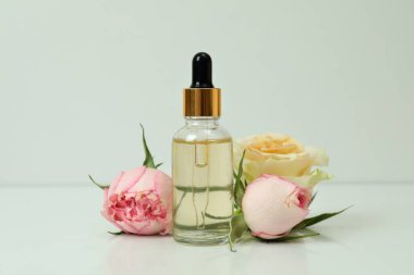 Beyaz arkaplanda gül yağı ve güller