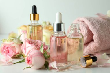 Beyaz arka planda gül yağı içeren cilt bakımı kavramı, kapat