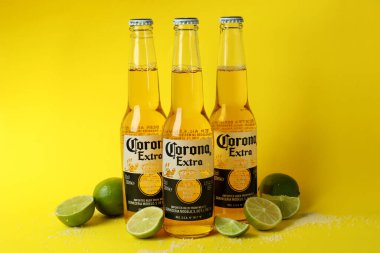 Bir şişe Corona Extra, sarı arka planda limon ve tuz.