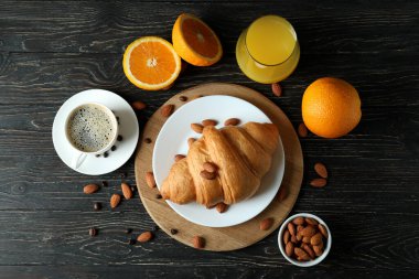 Tahta arka planda kruvasanla lezzetli kahvaltı kavramı