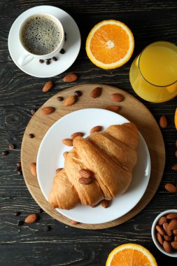 Tahta arka planda kruvasanla lezzetli kahvaltı kavramı