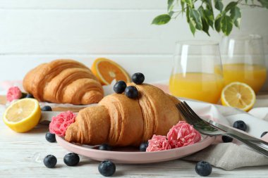 Beyaz ahşap arka planda kruvasan ile lezzetli kahvaltı kavramı