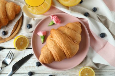 Beyaz ahşap arka planda kruvasan ile lezzetli kahvaltı kavramı