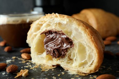 Koyu arkaplanda çikolatalı kruvasanla lezzetli kahvaltı kavramı