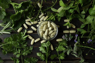 Ahşap masa üzerinde bitkisel ilaç hapları konsepti.