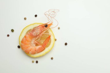 Beyaz arka planda lezzetli pişmiş karides ve baharatlar.