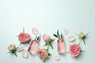 Beyaz arka planda gül yağı ve güllerle cilt bakımı kavramı