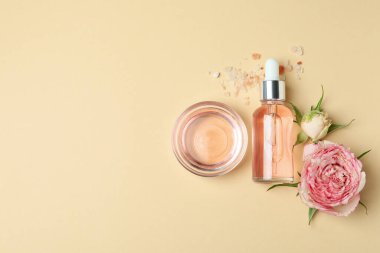 Bej arka planda gül yağı içeren cilt bakımı kavramı, metin için boşluk