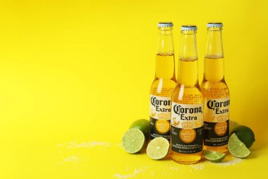 Bir şişe Corona Extra, sarı arka planda limon ve tuz.