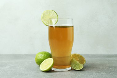 Beyaz desenli arka plana karşı bir bardak bira ve limon.