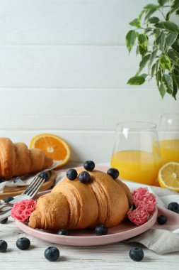 Beyaz ahşap arka planda kruvasan ile lezzetli kahvaltı kavramı