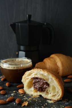 Koyu arkaplanda çikolatalı kruvasanla lezzetli kahvaltı kavramı