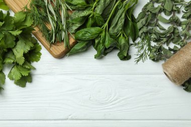 Beyaz ahşap arka planda taze bitkiler, metin için boşluk