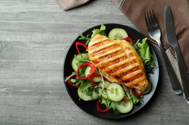 Gri desenli masada kızarmış tavuklu salata.