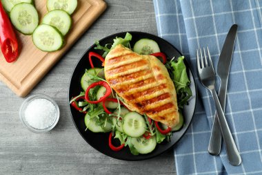 Gri desenli masada kızarmış tavuklu salata.