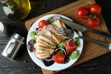 Ahşap masada kızarmış tavuklu salata.