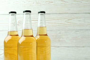 Beyaz ahşap arka planda bira şişeleri