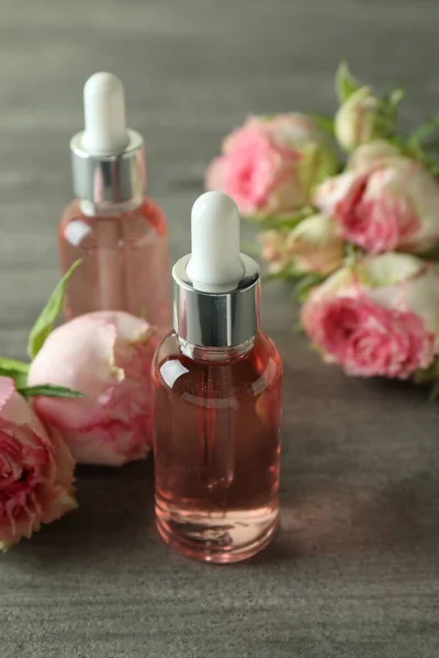 Bottiglie Con Olio Essenziale Rosa Sfondo Grigio Testurizzato — Foto Stock