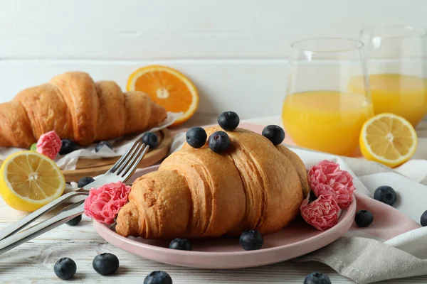 Beyaz ahşap arka planda kruvasan ile lezzetli kahvaltı kavramı