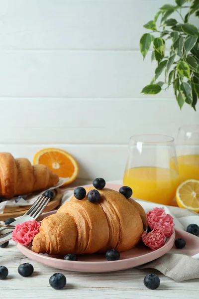 Beyaz ahşap arka planda kruvasan ile lezzetli kahvaltı kavramı
