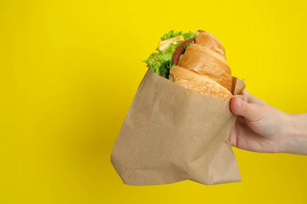 Femmina Mano Tenere Panino Croissant Sfondo Giallo — Foto Stock