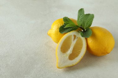 Beyaz dokulu arkaplanda olgun limonlar, metin için boşluk