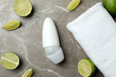 Boş deodorant, limon ve havlu gri masada.