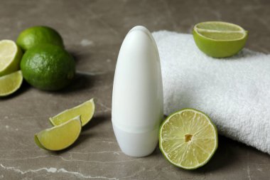 Boş deodorant, limon ve havlu gri masada.