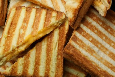 Arka planda leziz ızgara sandviçler var.