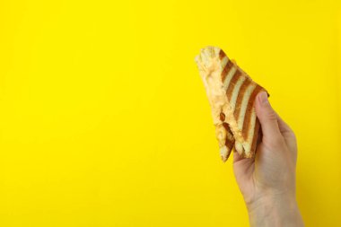Sarı arka planda peynirli ızgara sandviç.