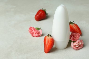 Beyaz deodorant, çilek ve çiçek desenli masa.