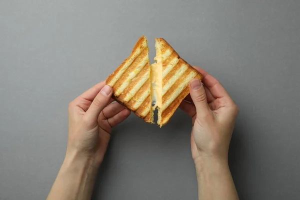 Weibliche Hände Halten Gegrilltes Sandwich Mit Käse Auf Grauem Hintergrund — Stockfoto