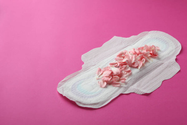 Гигиеническая прокладка с лепестками на розовом фоне