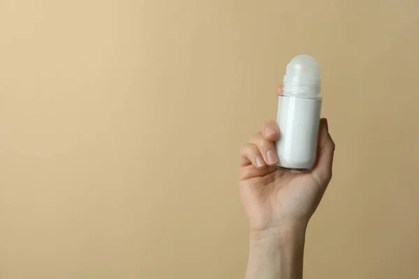 Kobieta Trzyma Pusty Dezodorant Beżowym Tle — Zdjęcie stockowe