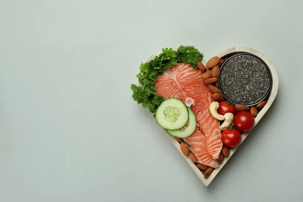 Healthy food in heart on light gray background