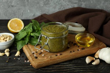 Ahşap zeminde yemek pişirmek için pesto sosu ve malzemeler.