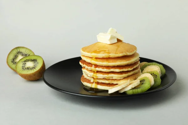 Platt Med Läckra Pannkakor Och Kiwi Grå Bakgrund — Stockfoto