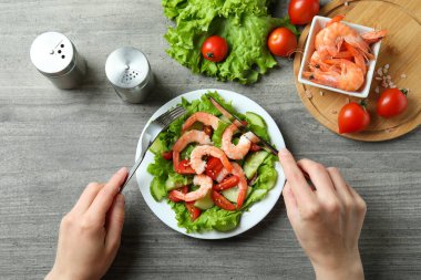 Gri ahşap masada karides salatasıyla lezzetli yemek kavramı