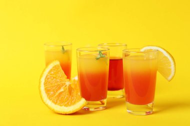 Tekila, gündoğumu kokteylleri ve sarı arka plandaki malzemeler.