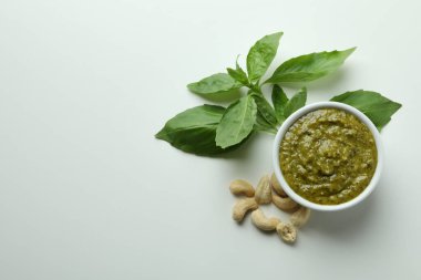 Beyaz arka planda pesto sosu ve malzemeler