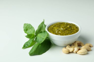 Beyaz arka planda pesto sosu ve malzemeler