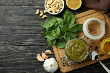 Ahşap zeminde yemek pişirmek için pesto sosu ve malzemeler.
