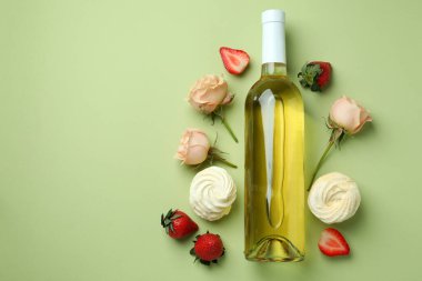 Tatlı yemek ve yeşil arka planda boş şarap şişesi.