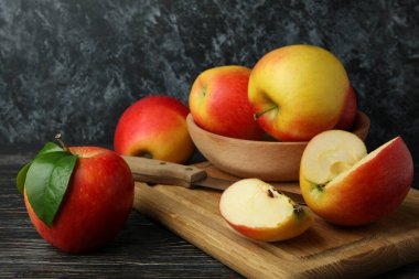 Ahşap masada lezzetli kırmızı elmalar olan bir tahta.