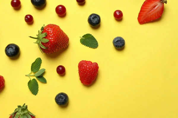 Delicious fresh berry mix on yellow background