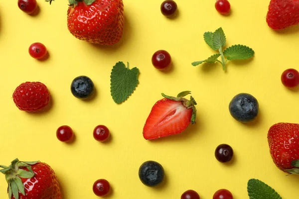 Delicious fresh berry mix on yellow background