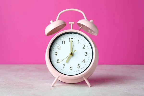 Reloj Despertador Sobre Mesa Blanca Texturizada Sobre Fondo Rosa —  Fotos de Stock