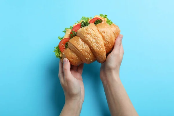 Mani Femminili Tenere Panino Croissant Sfondo Blu — Foto Stock