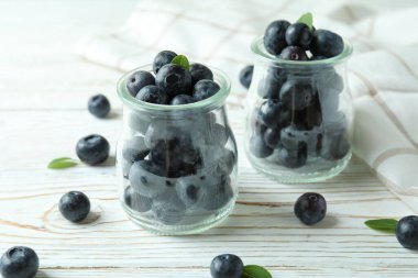 Beyaz ahşap masada yabanmersinli taze böğürtlen konsepti