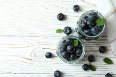 Beyaz ahşap masada yabanmersinli taze böğürtlen konsepti